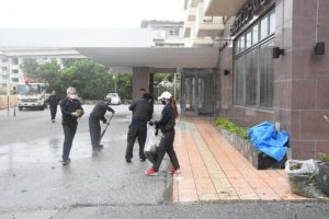 暴風で飛ばされた枝や葉っぱなどの片付けに追われる従業員ら＝５日、ホテルサザンコースト宮古島