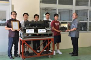 沖電燃料グループの下地さん（左）らが石炭を寄贈した＝21日、宮古工業高校