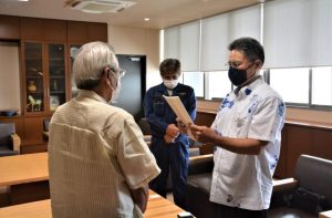友利会長（右）が座喜味市長（左）へ要請書を読み上げた＝27日、市役所