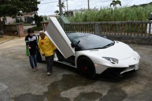 ランボルギーニで敬老会会場まで送迎してもらった石原さん（右）＝10月30日、長北集落センター