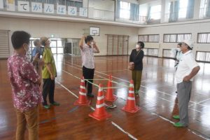 雨漏りで腐食した床の状況を確認する与党会派の市議ら＝22日、平良第一小学校体育館