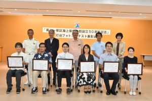 灯台フォトコンテストで入賞した皆さん(写真前列)と座喜味市長(後列中央)と関係者ら=1日、市役所