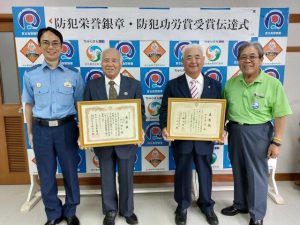 仲宗根署長（左）から表彰状が伝達された砂川さん（同２人目から）、浜比嘉さん。受賞を喜ぶ前川会長（右）＝17日、宮古島警察署