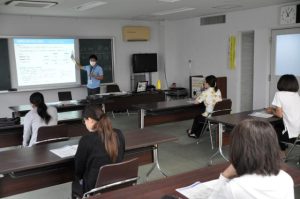 仲宗根さん（奥）の説明で参加した市民らがインボイス制度の基本的な仕組みについて学んだ＝29日、宮古島税務署