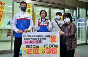 全国大会で銀と銅メダルを獲得して笑顔で帰島した丸山さん（左から２人目）＝１日、宮古空港