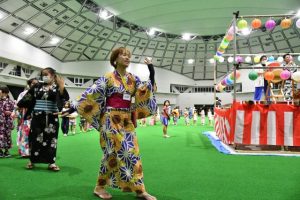 盆踊りでは浴衣姿の参加者らがやぐらを囲み踊った=26日、JTAドーム宮古島