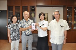 大城教育長と座喜味市長に３０００万円の目録を贈呈する上田さん（左から２人目）と妻の和子さん（左）＝15日、市役所