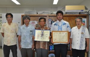 漁業振興功績者として表彰された伊良波さん（中央）、交流大会実績報告で最優秀賞を受賞した与那覇さん（右から２人目）。右は砂川所長＝28日、県宮古農林水産振興センター