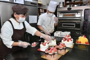 子供たちが笑顔になるクリスマスケーキ作りがピークを迎えている＝23日、市平良のケーキ店