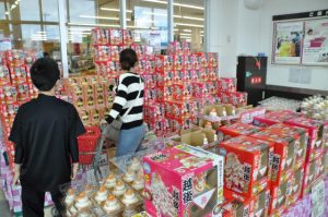 鏡餅など正月用の飾り付けを品定めする買い物客＝28日、市内の大型スーパー