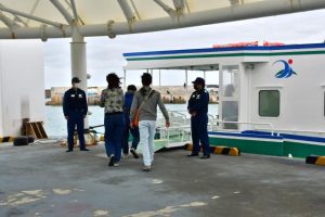 船舶の出入り口を警戒する海保職員ら＝25日、島尻漁港