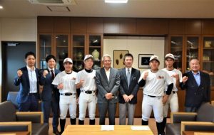 坂口キャプテン（左から４人目）らが座喜味市長（中央）に大会結果を報告した＝11日、市役所