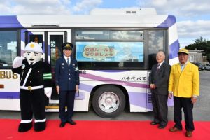 交通安全広報バスの運航を喜ぶ（写真左から）宮古島まもる君、仲宗根署長、砂川社長、友利会長＝31日、八千代バス・タクシー