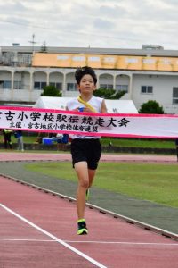 ゴールテープを切る久松のアンカー新里君＝21日、市陸上競技場