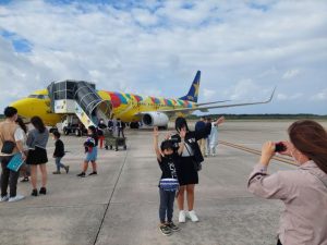 搭乗前、機体をバックに記念撮影した＝22日、下地島空港