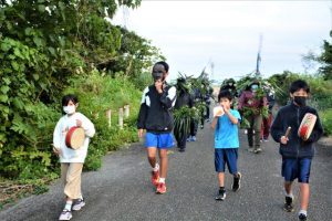 パーントゥを中心に集落内を歩いて厄を払った＝19日、上野の野原集落