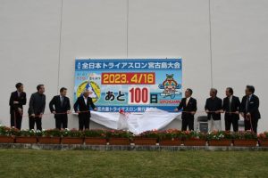第37回全日本トライアスロン宮古島大会開催まで１００日を迎え、残歴板除幕を行う関係者＝６日、市役所