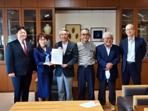 平良委員長（左から２人目）から平良庁舎の利活用計画案の内容が座喜味市長（同３人目）に報告された＝９日、市役所