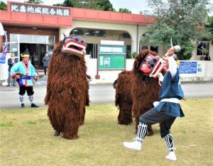 ２頭の獅子が新しく購入された車などの厄払いを行った＝10日、比嘉公民館前