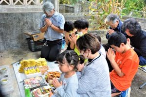 旧十六日祭では先祖に手を合わせ供養が行われた＝６日、平良下里の墓地