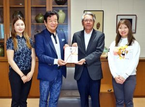 高橋会長（左から２人目）から座喜味市長（同３人目）に環境保全活動に役立ててと寄付金が贈呈された＝14日、市役所