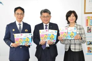 （右から）大城教育長にドリルを贈った崎原副社長、同席した仲宗根署長＝21日、市教育委員会