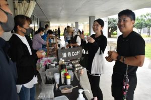 会話を楽しみながらモズクを試食する来場者ら＝25日、みやこ下地島空港ターミナル