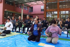 演奏会に参加した会員らは、主題曲の「かぎやで風」を一斉に奏で披露した＝４日、豊見城市中央公民館交流広場