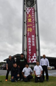 サッカー関係者と両親らが参加して懸垂幕を掲揚した＝28日、市役所前