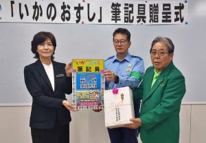 喜屋武署長（中央）と前川会長（右）から大城教育長へ筆記具が贈られた＝７日、市役所
