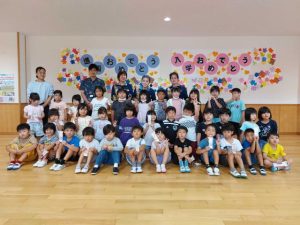 宮國部長（後列右から２人目）らからお守りがプレゼントされた＝21日、伊良部島小中学校