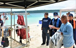 海保職員らが、ライフジャケットの適正着用を促した＝29日、前浜ビーチ