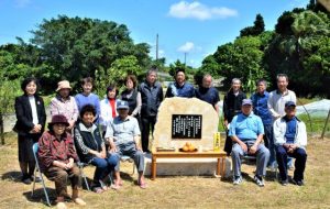 石碑を囲む砂川さんの親戚、自治会の皆さん＝２日、城辺の七又集落