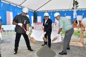 くわ入れする（左から）下地社長、前田理事長、翁長社長＝12日、平良西里の旧平良支店跡地