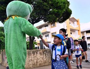 署員、会員らが登校してくる児童と笑顔であいさつを交わした「朝のあいさつ運動」＝12日、東小正門前