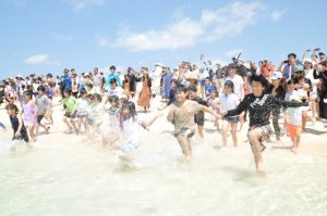 初泳ぎで水しぶきを上げながら海に飛び込む子供たち＝２日、与那覇前浜ビーチ