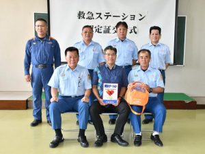 認定証を手にする友利副総支配人（前列中央）＝11日、市消防本部