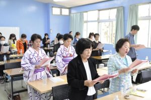 総会で「心のともしび」を斉唱する新城会長（手前）ら会員たち＝13日、宮古更生保護サポートセンター