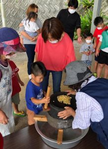 昔ながらの豆腐づくりを楽しむ参加者ら＝14日、市城辺社会福祉センター（提供写真）