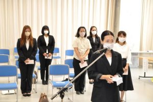 入学生代表で宣誓する居垣さん（手前）＝28日、市未来創造センター研修室