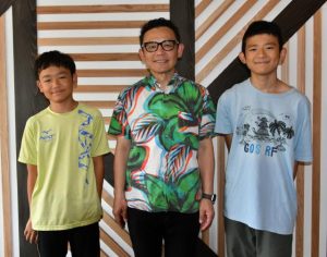 長男の匠洋さん（右）、次男の俊太さん（左）に囲まれて笑顔の正樹さん