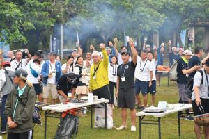 祝杯を掲げる参加者ら=14日、荷川取漁港公園