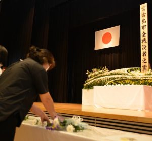 参列者らが献花を行い、み霊を慰めた市全戦没者追悼式および平和祈念式＝23日、市未来創造センター多目的ホール