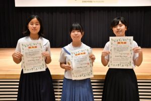 スピーチの部の上位入賞者。(左から)佐渡山さん、城間さん、友利さん=17日、市未来創造センター多目的ホール