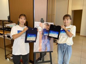 長間浜がプリントされたビラボンとのコラボレーションＴシャツを着るスタッフ＝23日、シーウッドホテル