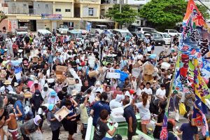 カツオのぶつ切りを取ろうと島民や観光客らでにぎわった4年ぶり開催のオオバンマイ(大盤振る舞い)=21日、佐良浜漁港