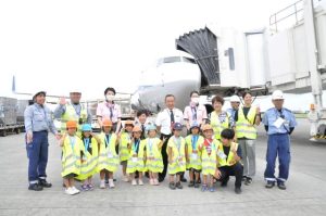 機長らと記念撮影する心愛保育園の４、５歳児ら＝28日、宮古空港駐機場