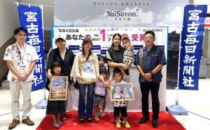 フォトコンテスト受賞者の皆さん。左は久場俊秀店長、右は山内社長＝18日、サンエー宮古島シティ