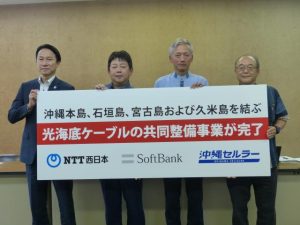 3社共同による光海底ケーブル整備事業が完了したことを発表する沖縄セルラー電話の菅社長(右から2人目)ら=13日、県庁