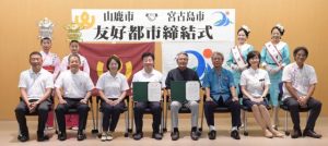 両市の関係者らが見守る中、友好都市を締結した座喜味市長(前列右4人目)と山鹿市の早田市長(同5人目)=20日、市役所